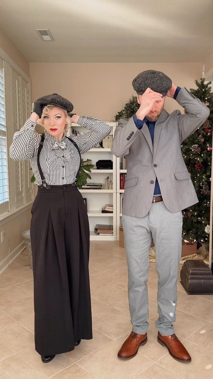 A man and woman posing in 1920s inspired outfits with berets and vintage clothing.