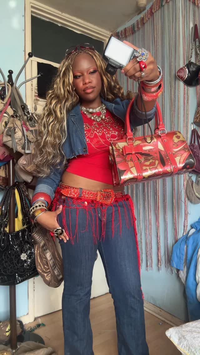 A woman wearing a denim jacket and denim flare jeans posing for a selfie.