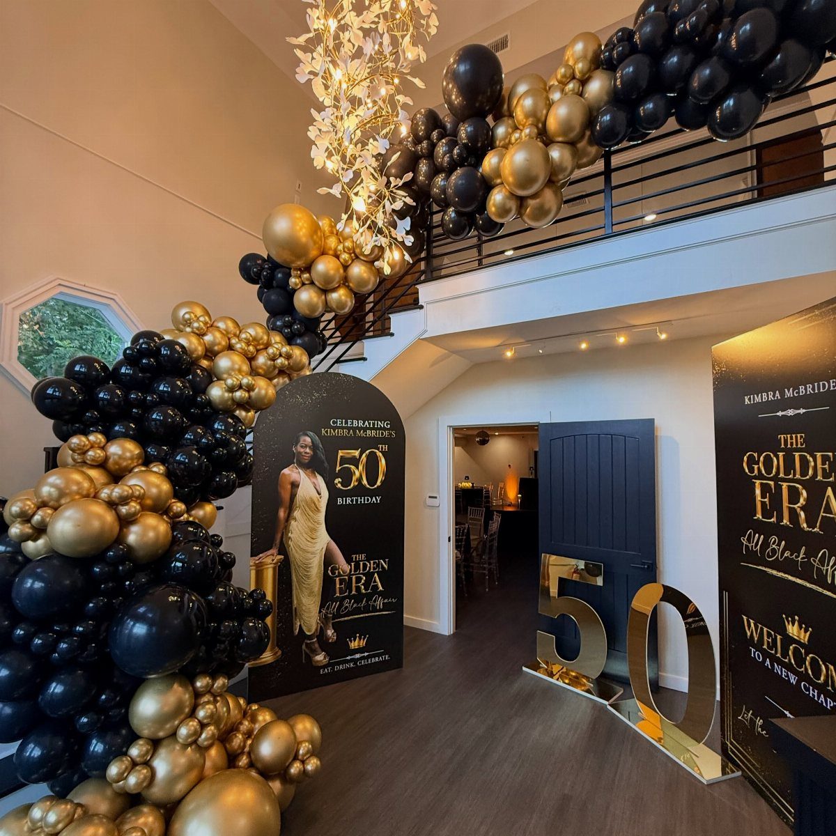 Black and gold balloon arch decorating a room for a 50th birthday celebration.