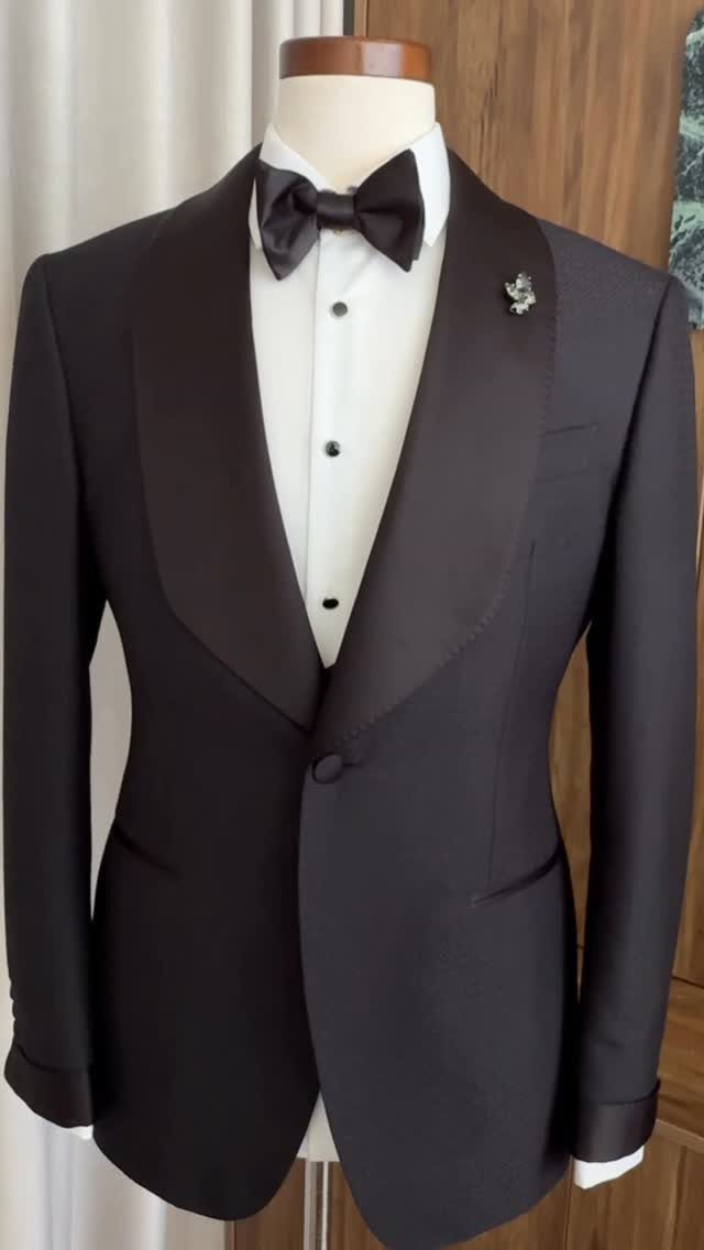 A black tuxedo with a bow tie displayed on a white mannequin torso.