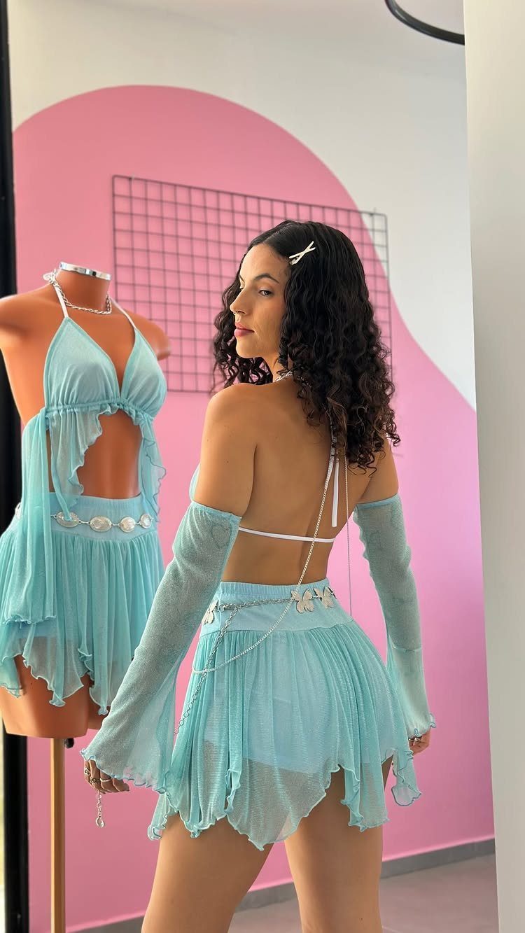 Woman posing in a light blue sheer mesh two-piece outfit with matching long sleeves.