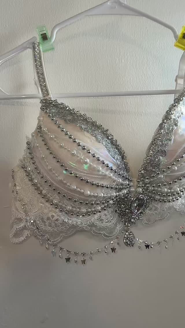 A white lace bra top decorated with silver rhinestones, pearls, and dangling beaded chains.