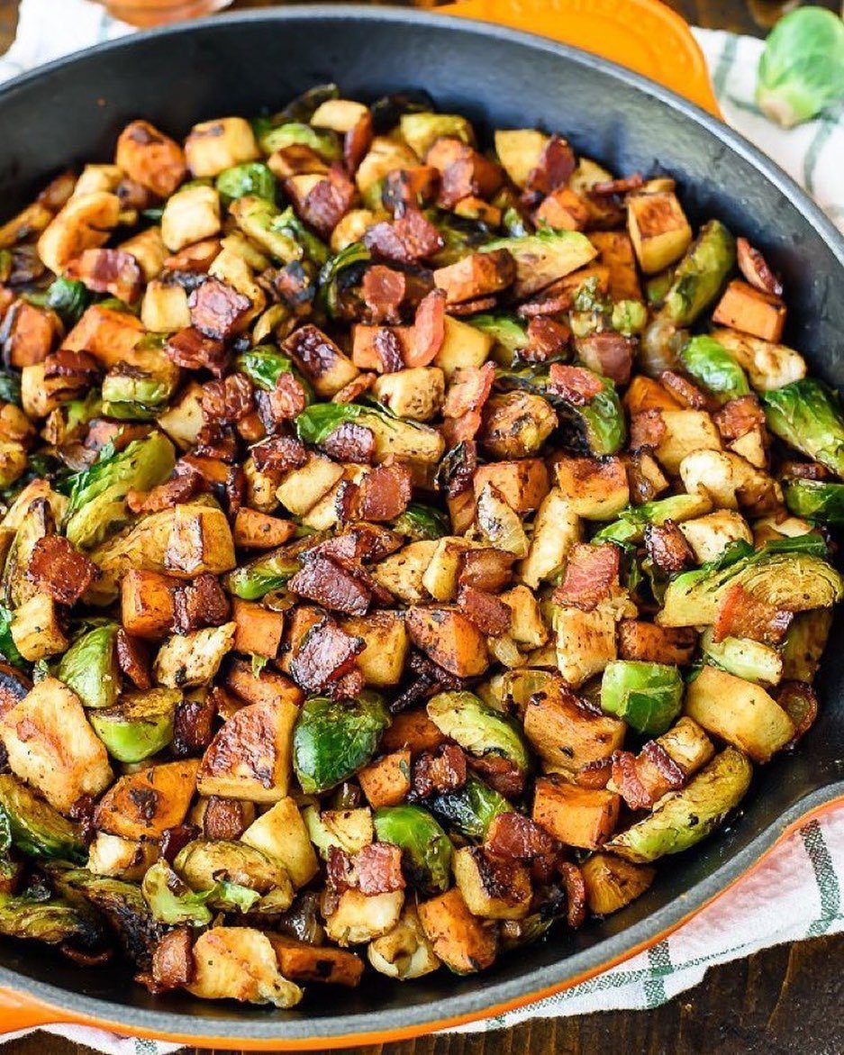 Roasted Brussels sprouts, bacon, and chicken pieces served in a large black skillet.