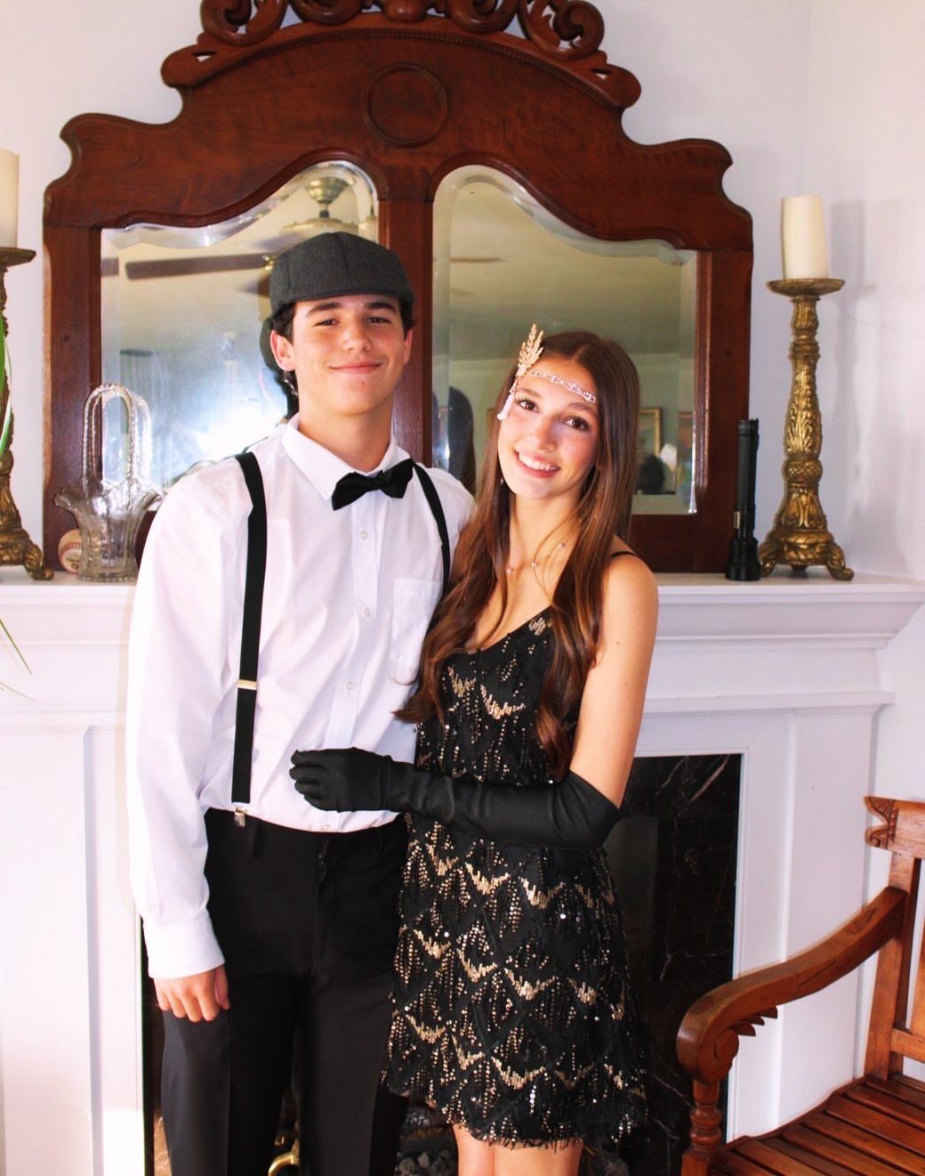 Teenage boy and girl posing in 1920s inspired flapper and gentleman costumes.