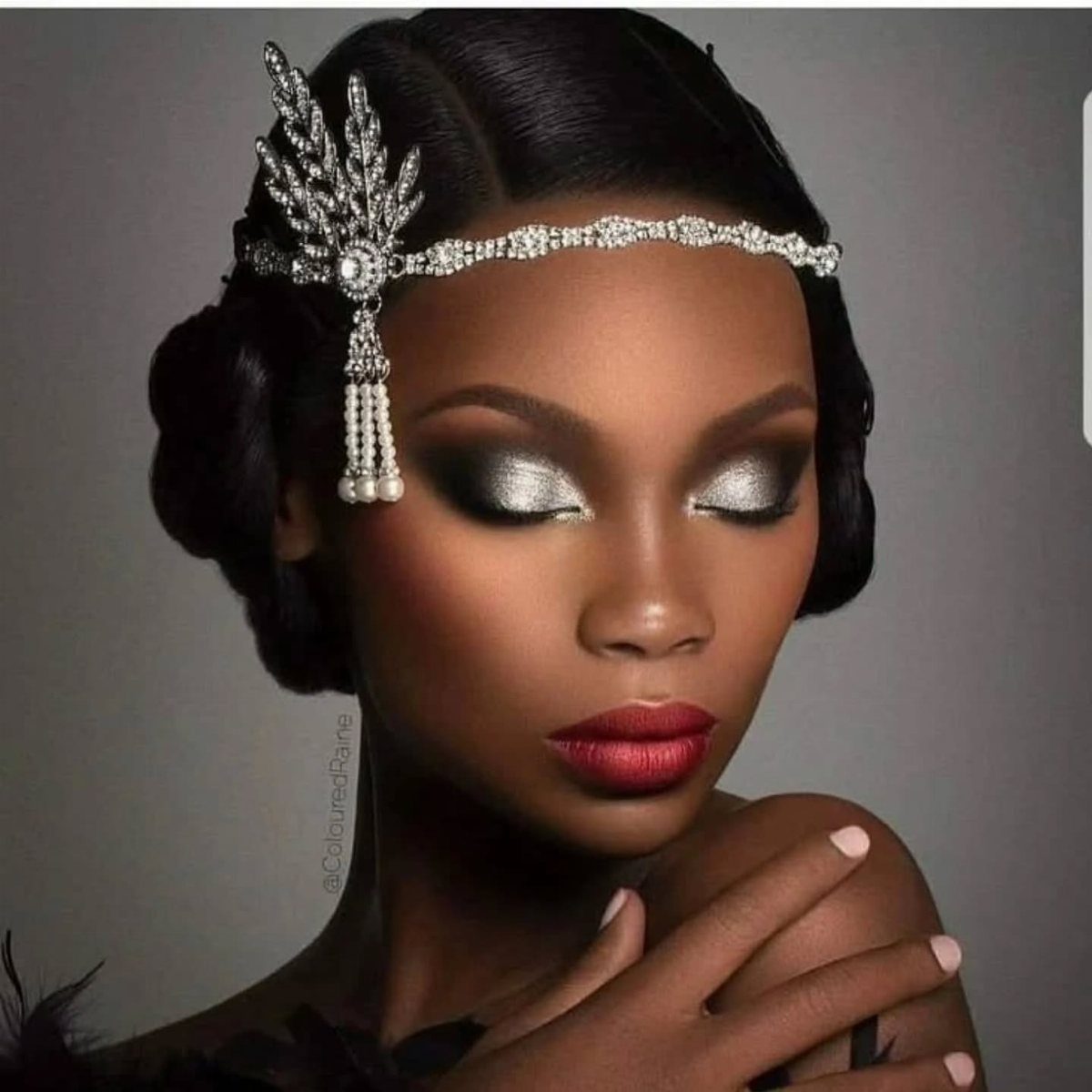 Woman wearing a sparkling silver Art Deco headband with pearls and dramatic silver eye makeup.
