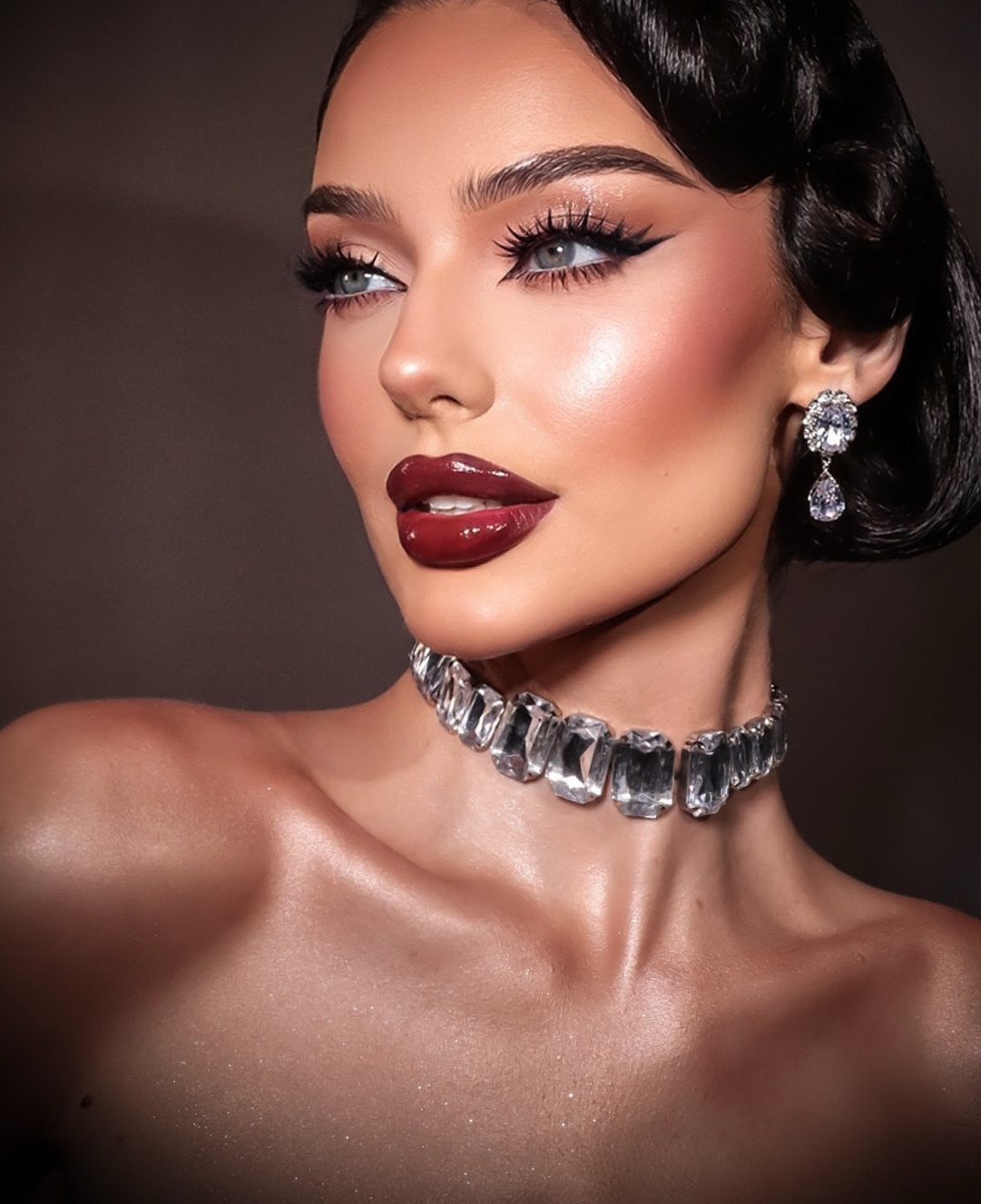 Woman with dark finger wave hair, bold red lips, and sparkling crystal jewelry.