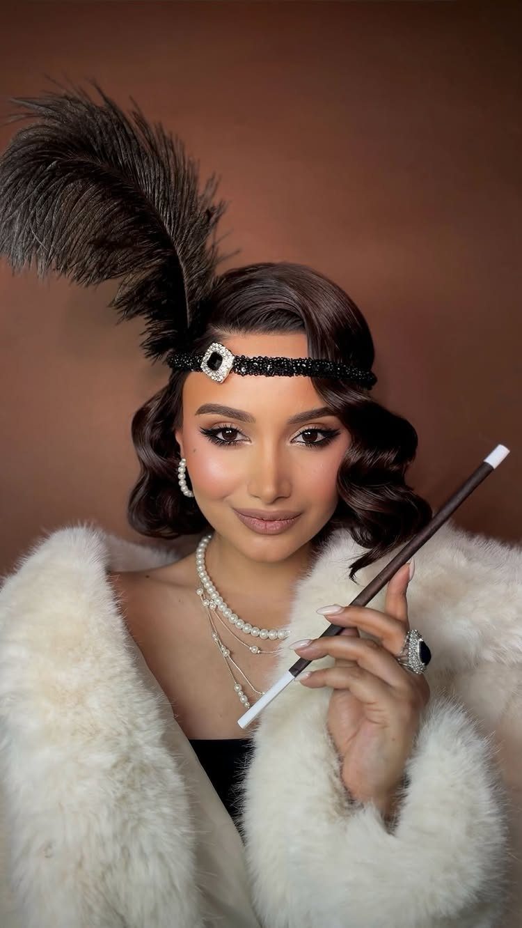 Woman wearing a black beaded Art Deco headband with a large feather and pearl necklaces.