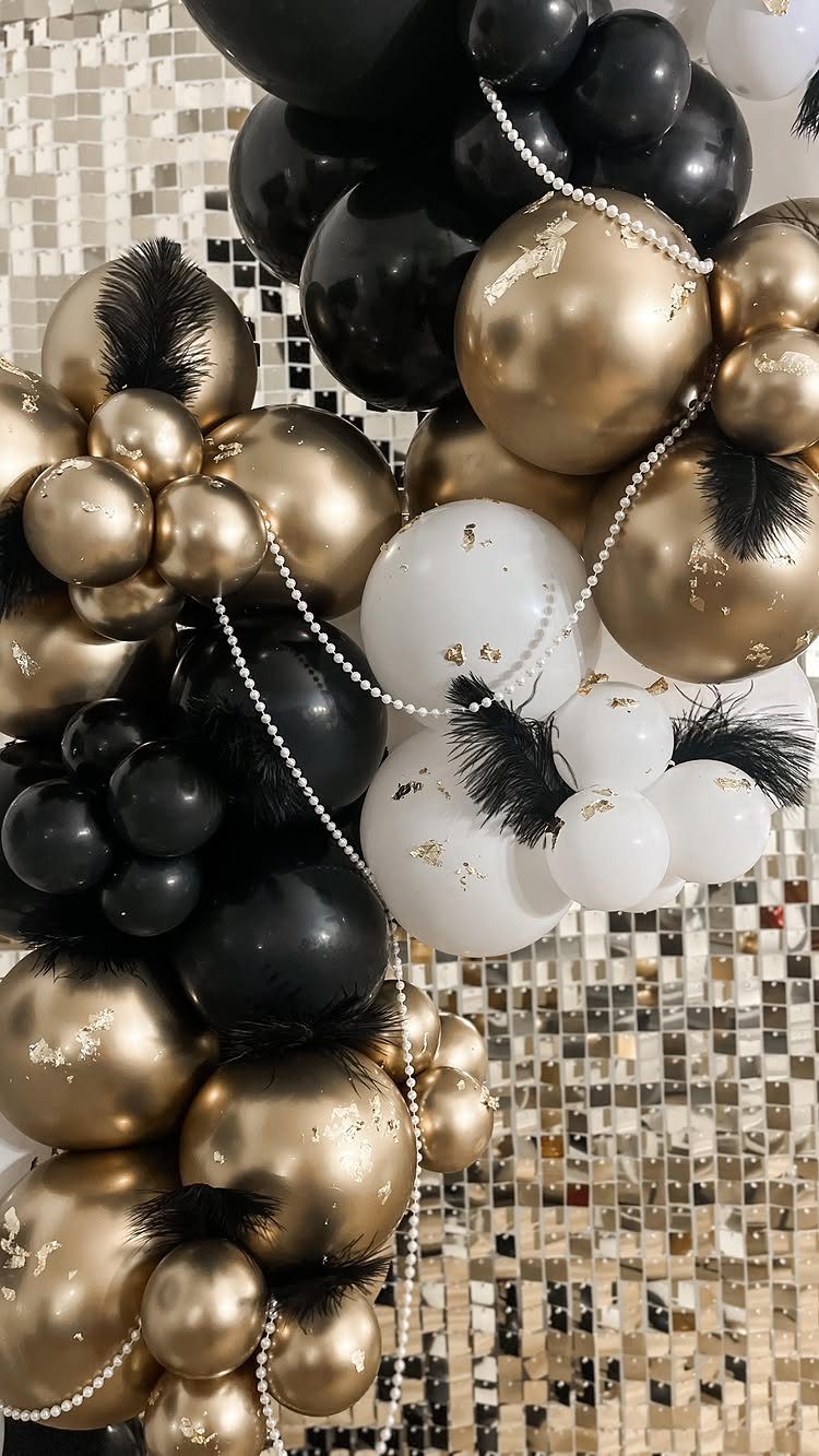 Gold, black, and white balloons with feathers and pearls against a sequin background.