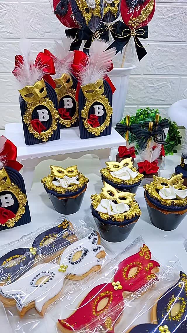 Masquerade themed desserts including gold mask cupcakes, cookies, and navy blue decorated treat boxes.
