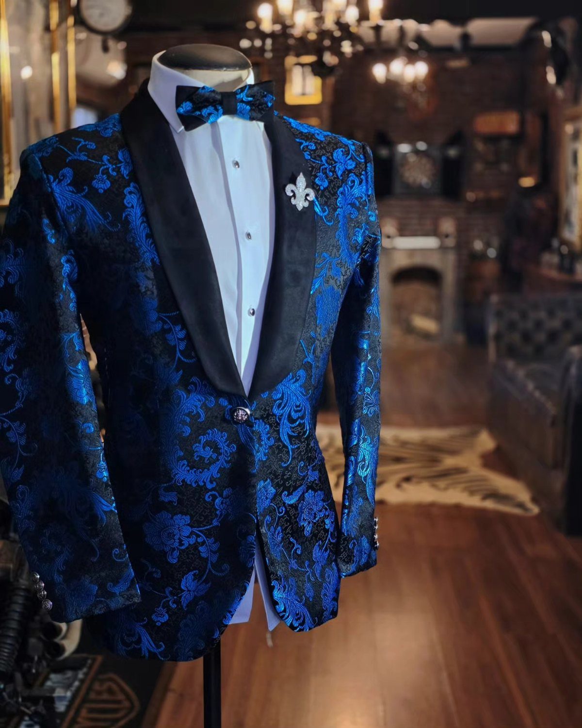 Blue and black patterned brocade tuxedo jacket on a mannequin with a black bow tie.