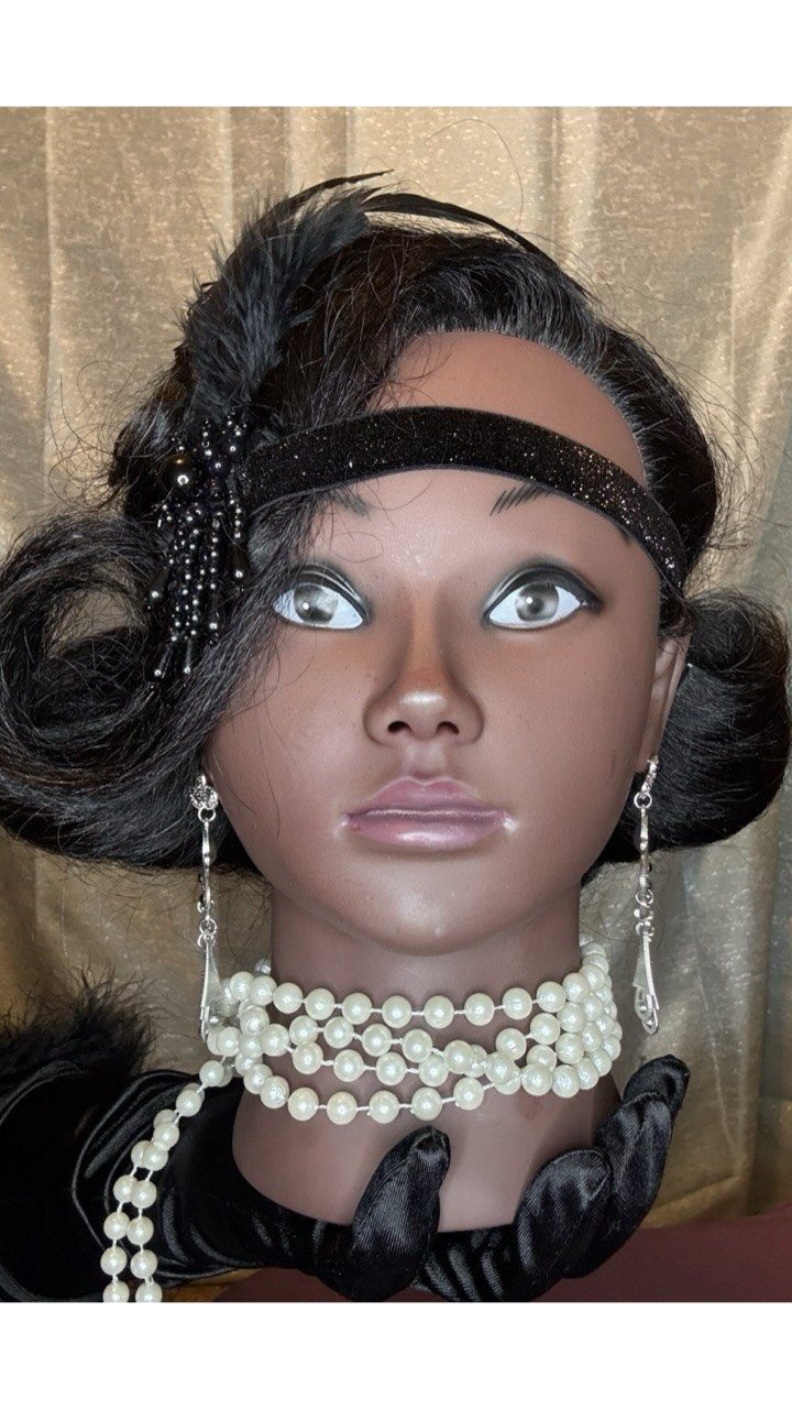 Mannequin head wearing a black sequined headband, pearl necklace, and silver drop earrings.