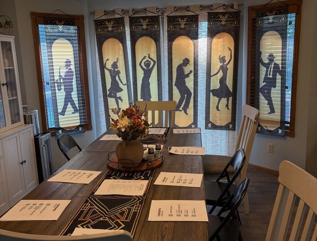 A dining table set with themed decor and silhouettes of flappers on window curtains.