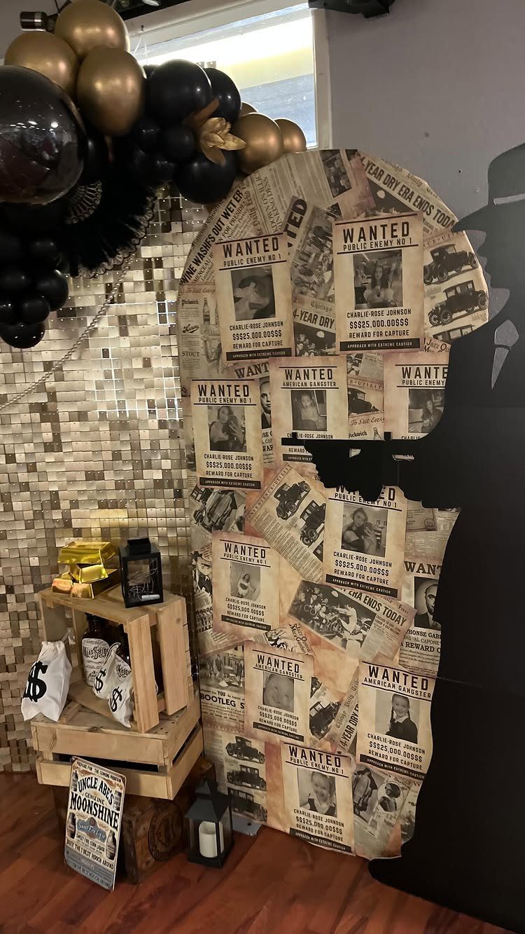 Party decorations with wanted posters, gold balloons, wooden crates, and money bags for a themed event.