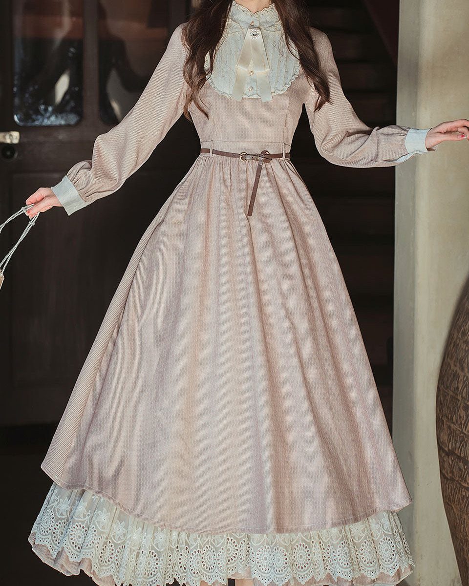 Woman wearing a vintage pinstripe tea length dress with white lace collar and hem.