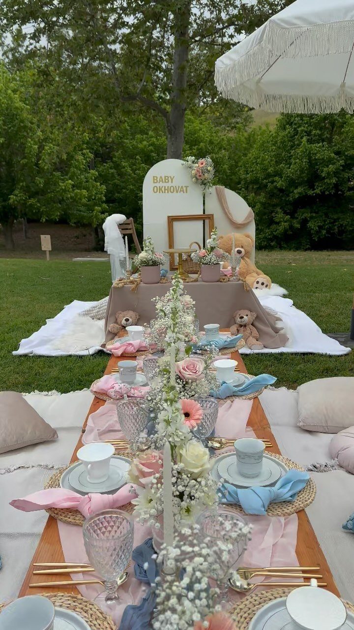 A decorated outdoor picnic table with pink and blue accents for a baby gender reveal.