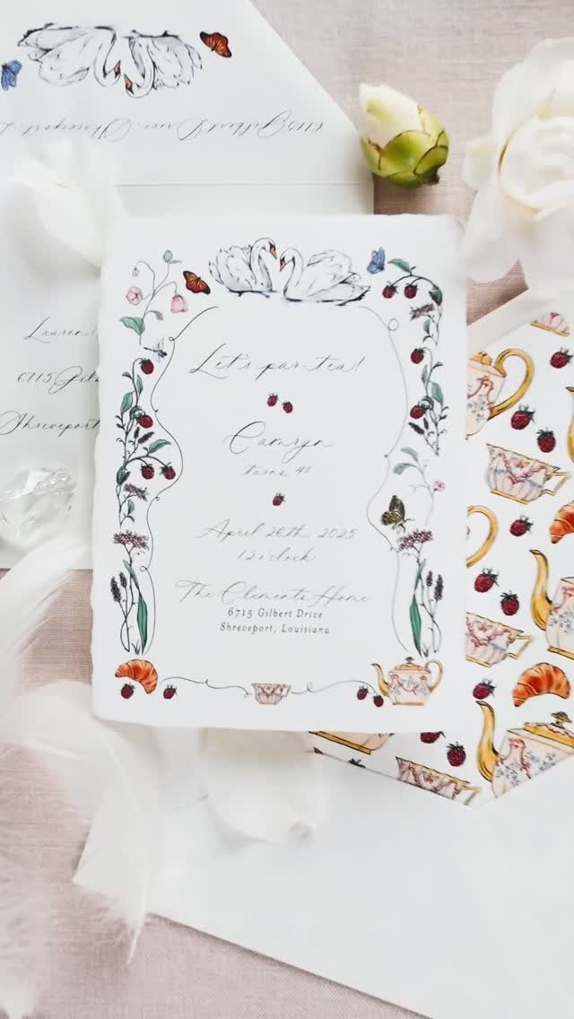 Floral tea party invitation card with teapot illustrations resting among white flowers and feathers.