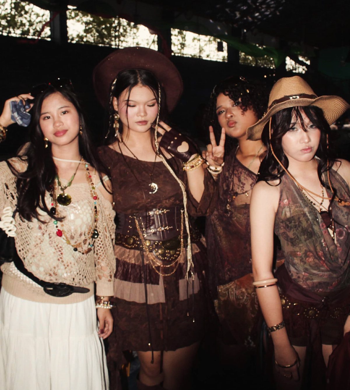 Four women posing in bohemian outfits with earthy tones and layered jewelry.