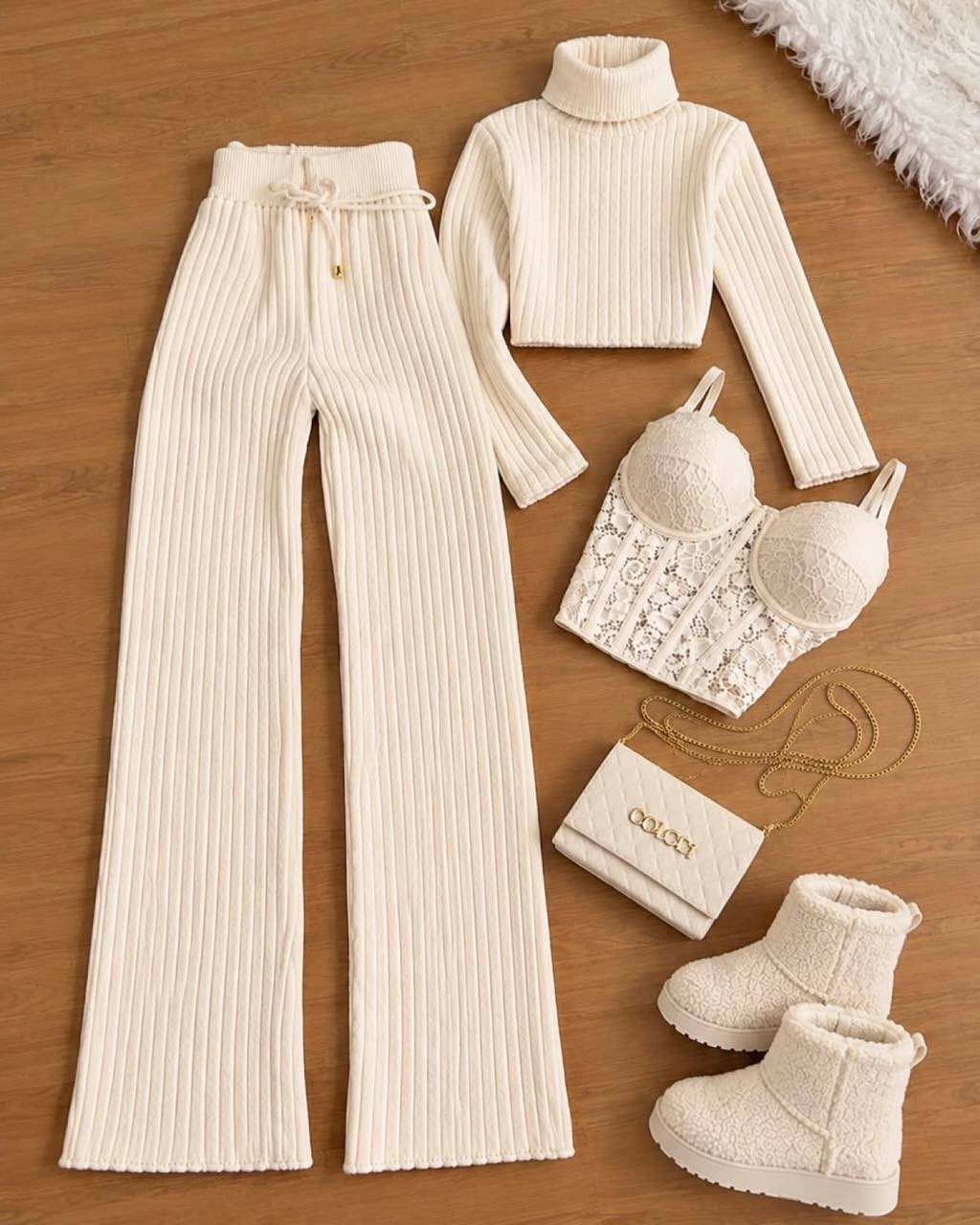 Cream ribbed knit turtleneck top and wide-leg trousers laid out with accessories.
