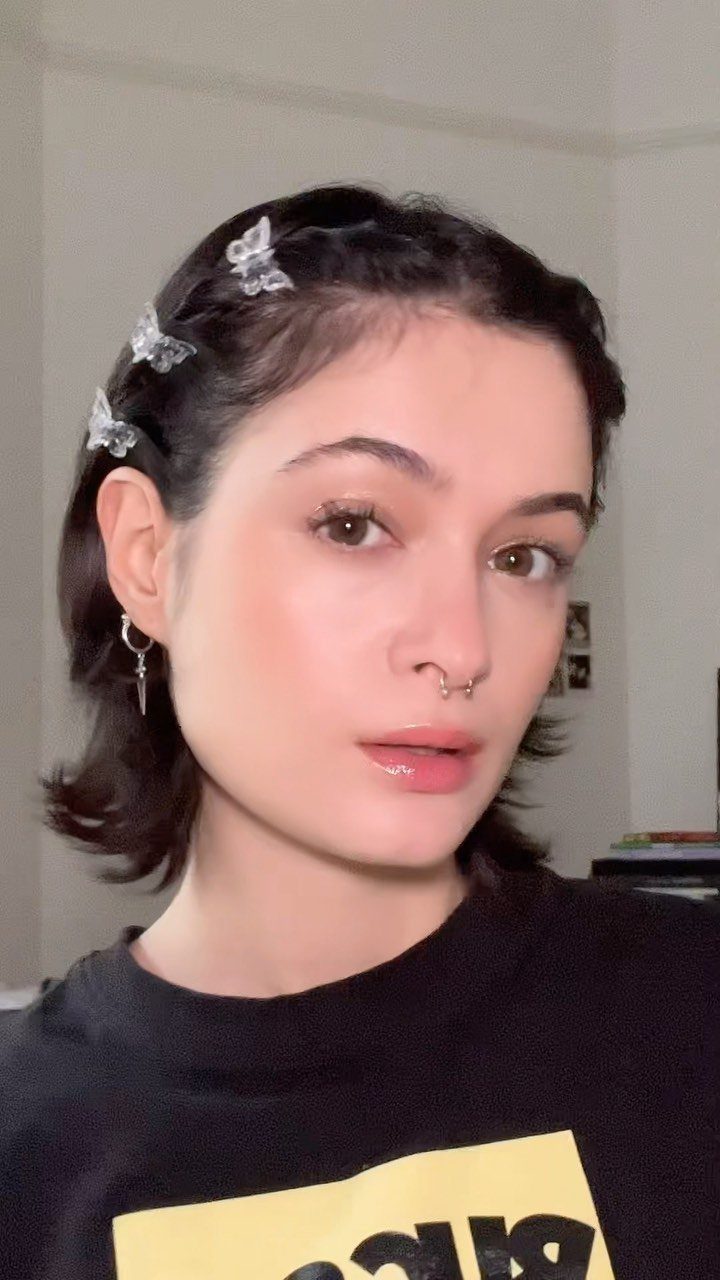Young woman with dark hair adorned with several translucent butterfly hair clips.