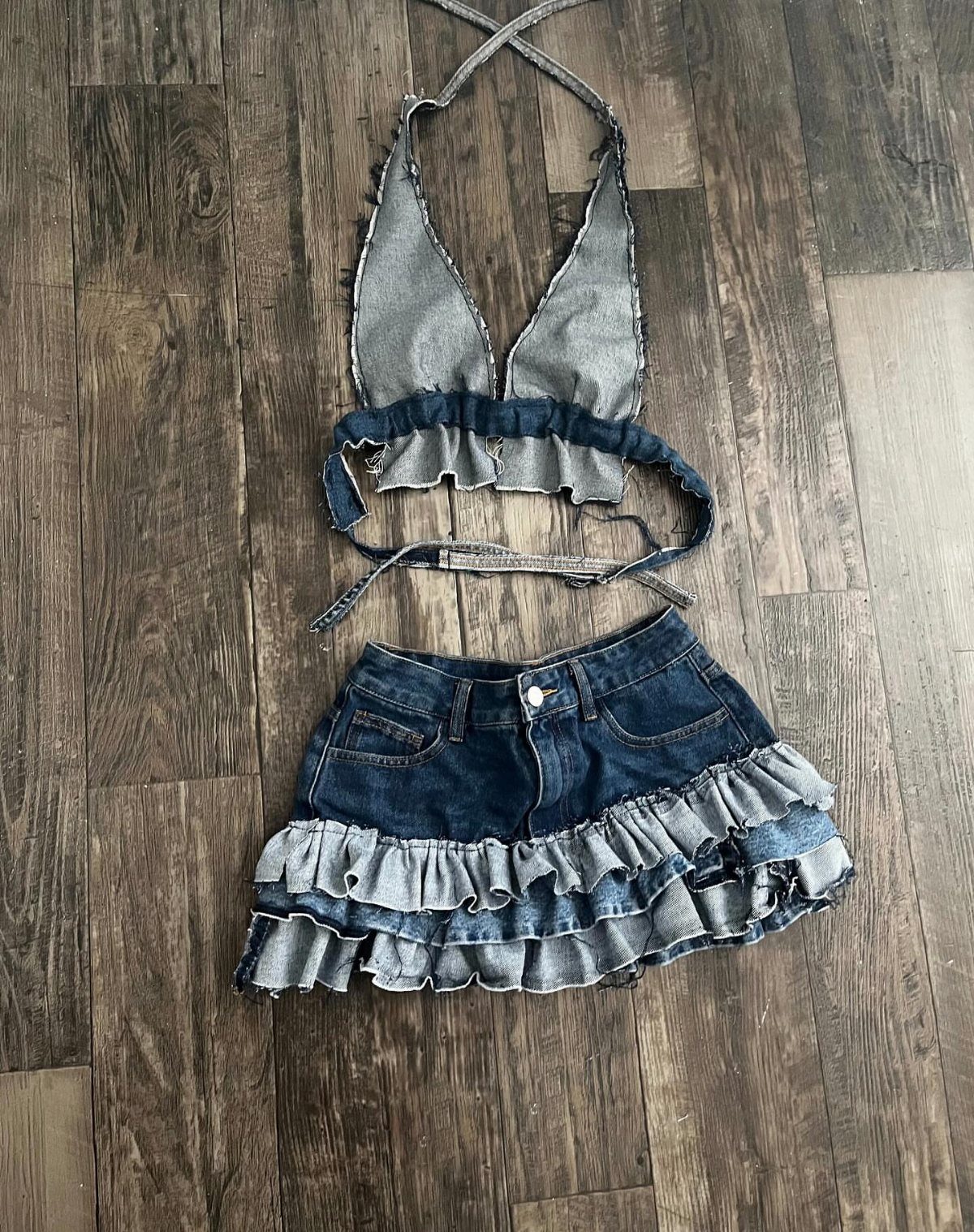 A two-piece denim outfit with a ruffled halter top and a tiered ruffled mini skirt.
